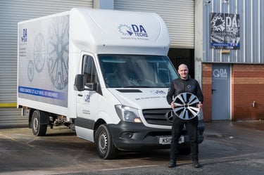 Director - Jamie Baxter stood infront of his mobile alloy wheel refurbishment van holding a diamond cutalloy wheel